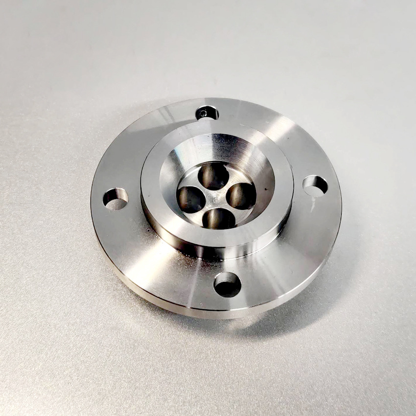 CNC turned stainless steel flange with a bolt circle and central bore, as-machined