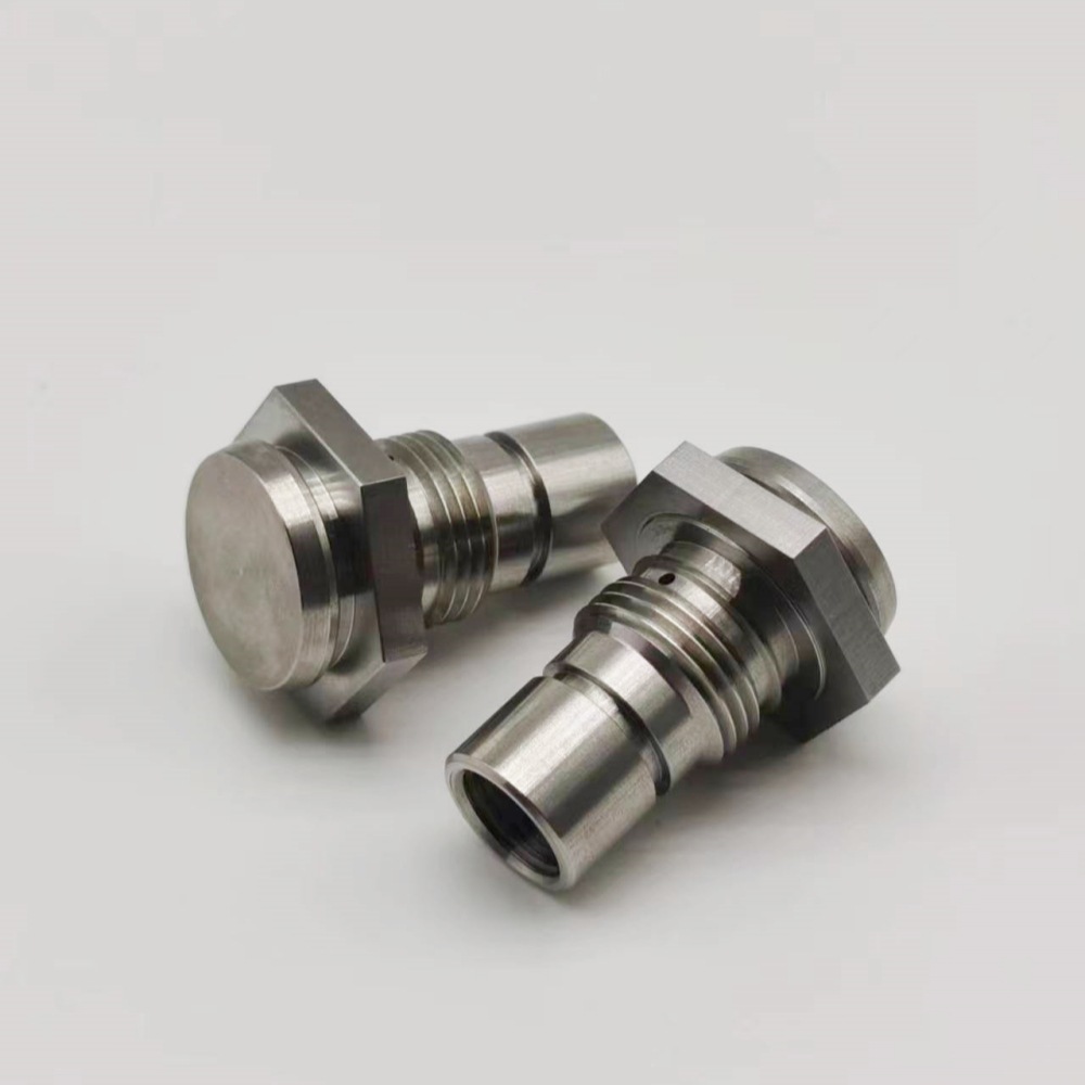 CNC turned stainless steel valve plugs with hex flats and threaded bodies, machined by GY Machining