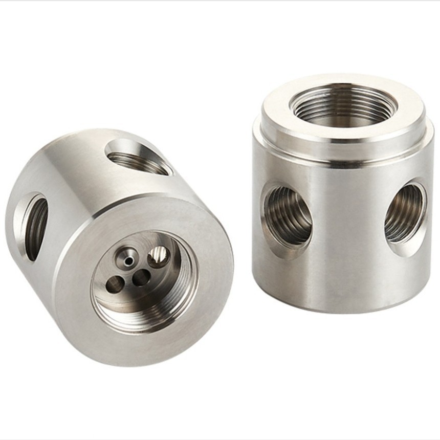 CNC machined stainless steel manifold blocks with tapped ports on five faces, machined by GY Machining