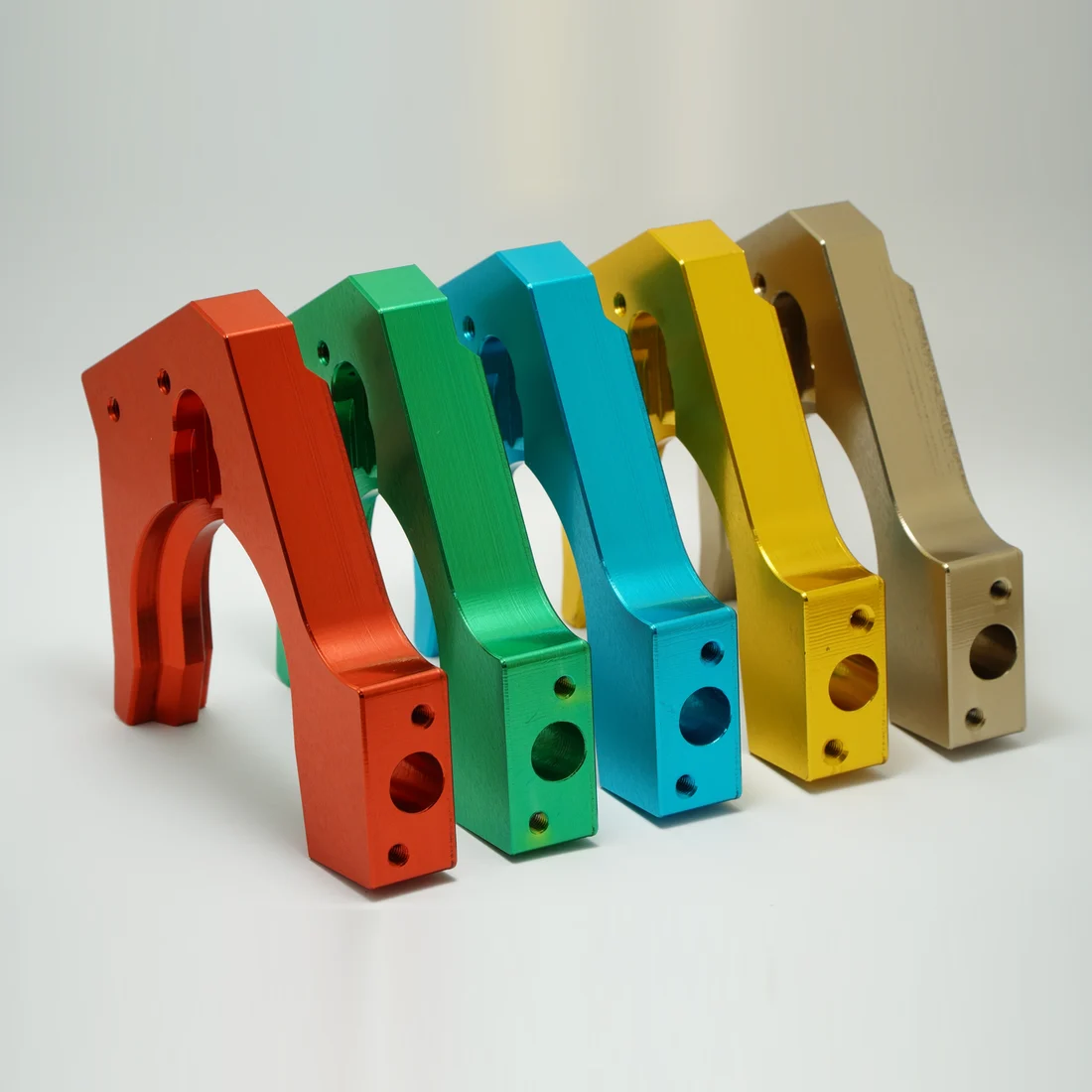 One CNC machined aluminium bracket anodised in five colours - red, green, cyan, yellow and clear
