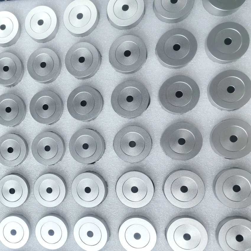 CNC machined aluminium discs with a uniform bead blasted matte finish, laid out in a tray