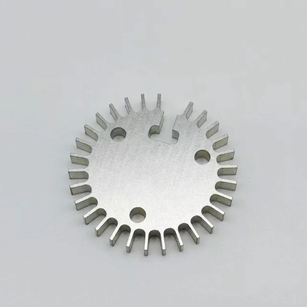 CNC machined aluminium heat sink disc with radial fins cut from solid and three mounting holes