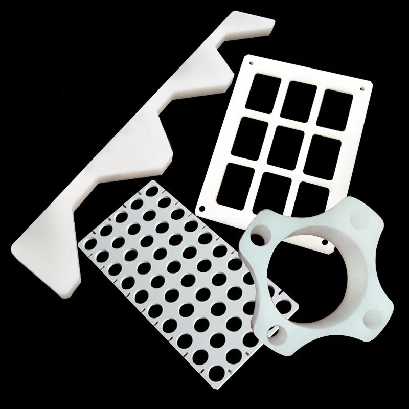 CNC machined white polypropylene plates and fixtures: pocketed rack, perforated plate, notched guide and four-lobe ring
