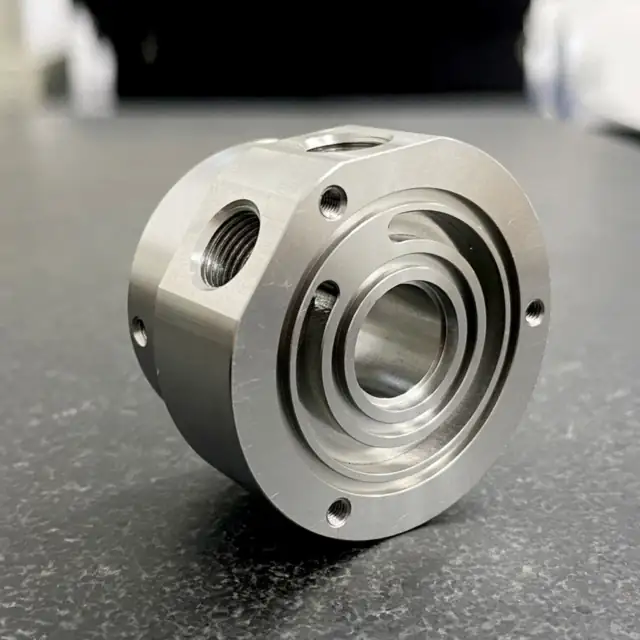 CNC machined stainless steel multi-port block with stepped bore and ta