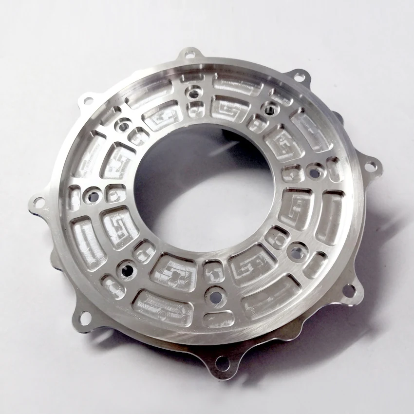 CNC milled aluminium clutch cover plate with pocketed webs, bolt holes and a central bore