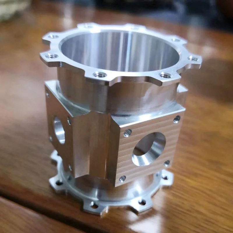 CNC milled aluminium cylinder housing with flanged ends and square side bosses, machined by GY Machining