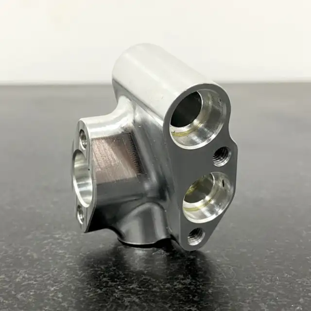 CNC milled aluminium elbow manifold block with counterbored ports and