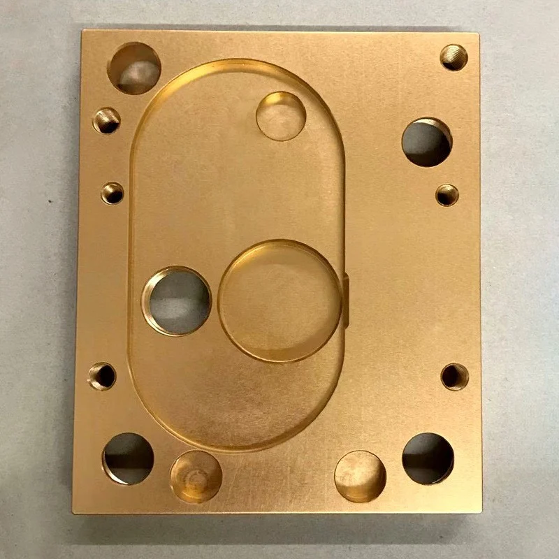 CNC milled brass plate with an oval pocket and a ring of bores
