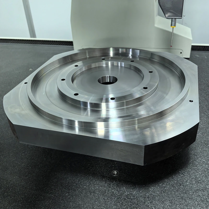 Large CNC milled aluminium base plate with concentric steps and bolt holes being measured on the bridge CMM at GY Machining