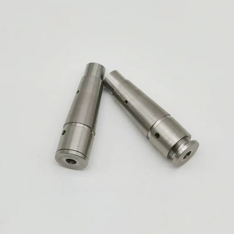 Two CNC turned stainless steel stepped pins with cross-drilled holes, a threaded neck and a flanged end, machined by GY Machining