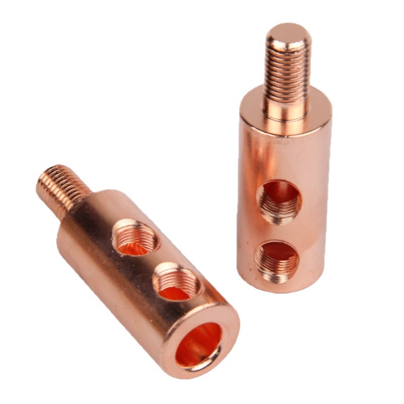CNC machined copper cable terminals with threaded studs, tapped side ports and a through bore, machined by GY Machining