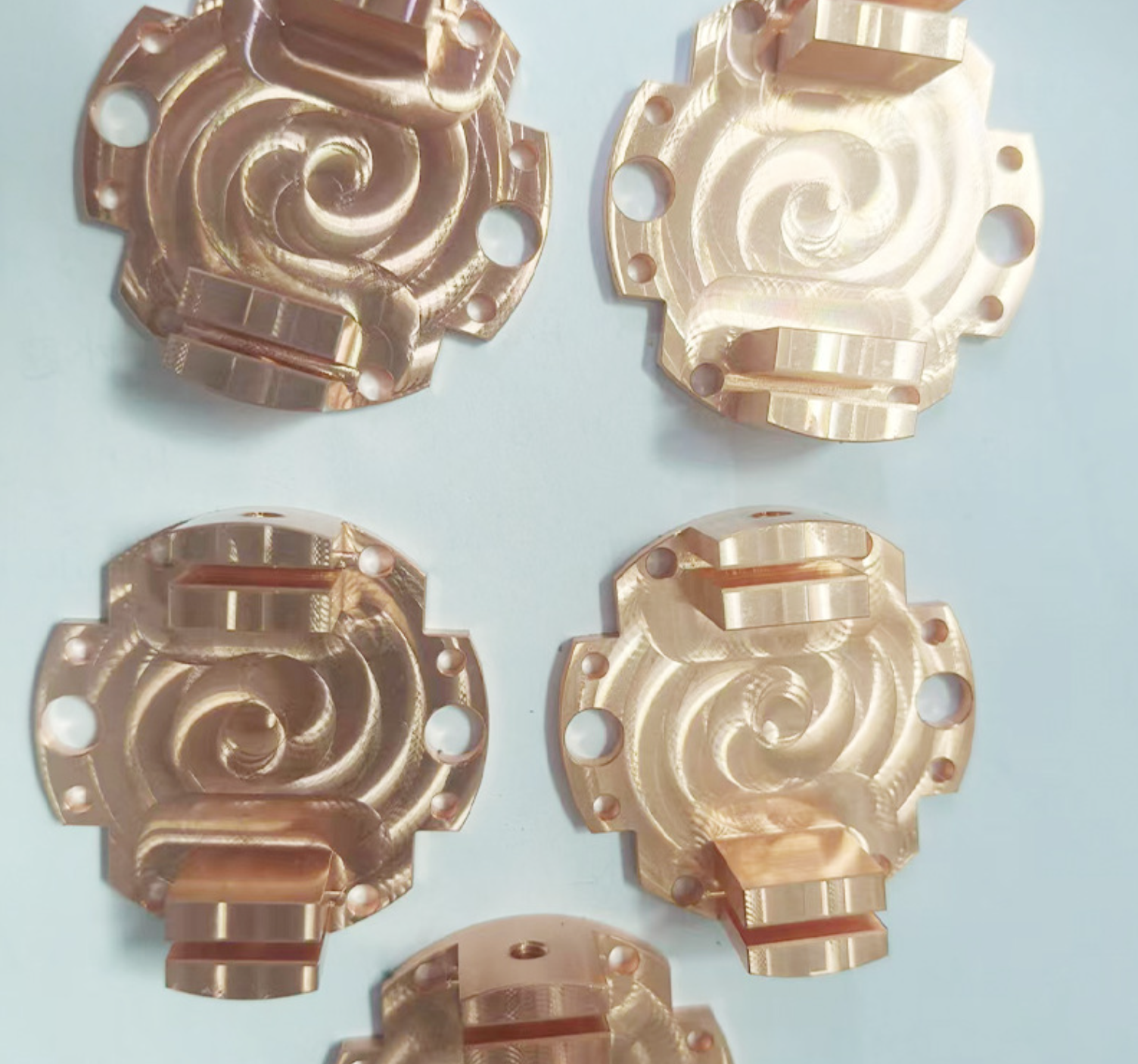 CNC machined brass spiral-wrap housings with mounting ears and side bosses, machined by GY Machining