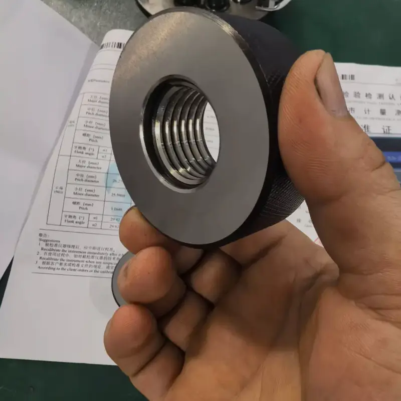 GO / NO-GO thread ring gauge held over its calibration certificate in the GY Machining measuring room