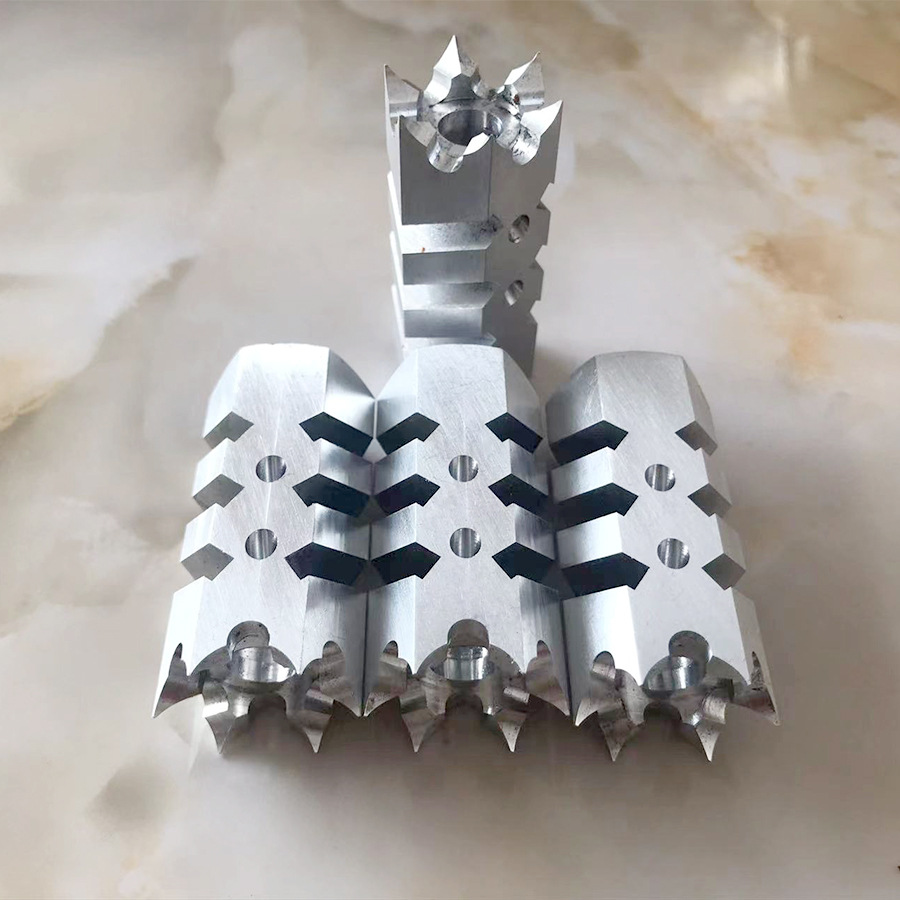 Machined aluminium finned blocks with dark inserts, lined up in a row &ndash; GY Machining