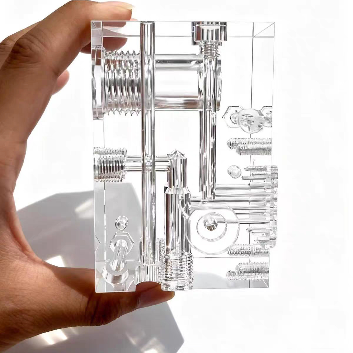 CNC machined clear acrylic block with internal bores and threaded ports