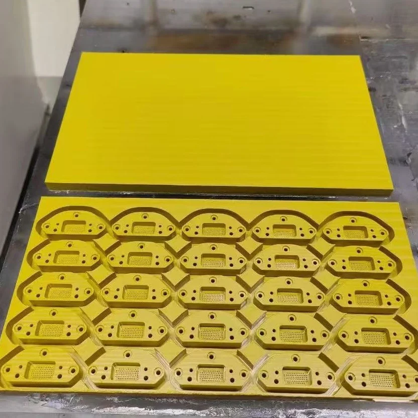 A PAI plate on the machine table with parts nested and machined into it, beside the uncut plate &ndash; GY Machining