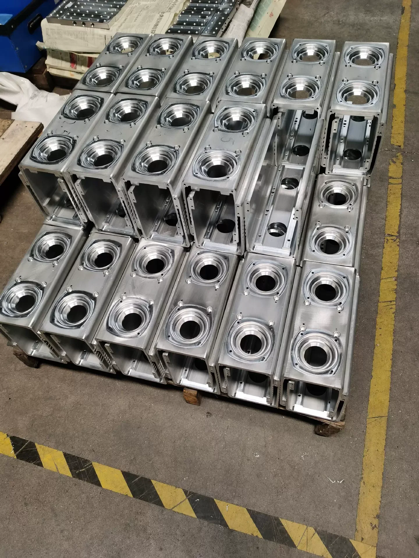 Production batch of CNC milled aluminium bearing housings on a pallet at GY Machining