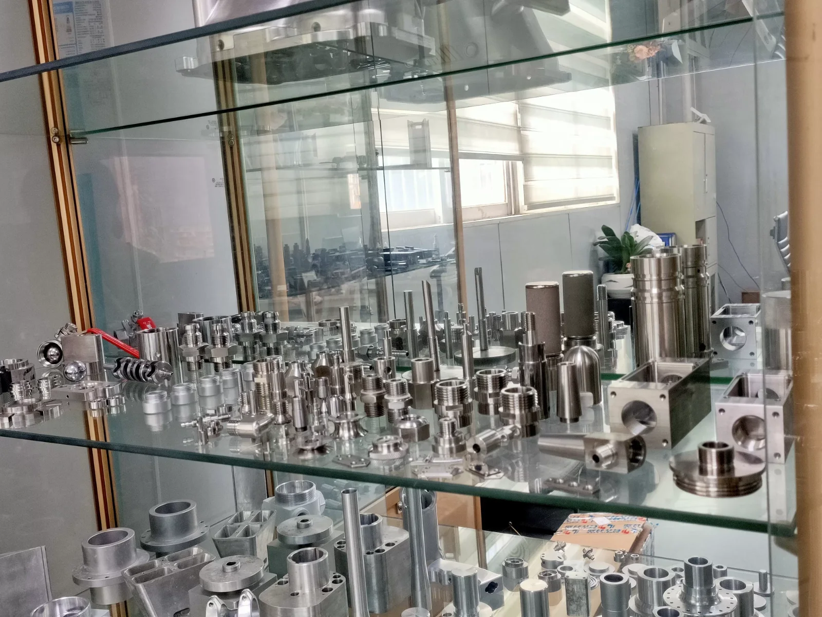 Sample cabinet shelf at GY Machining: stainless steel hydraulic fittings, adapters, valve blocks, manifolds and milled aluminium housings