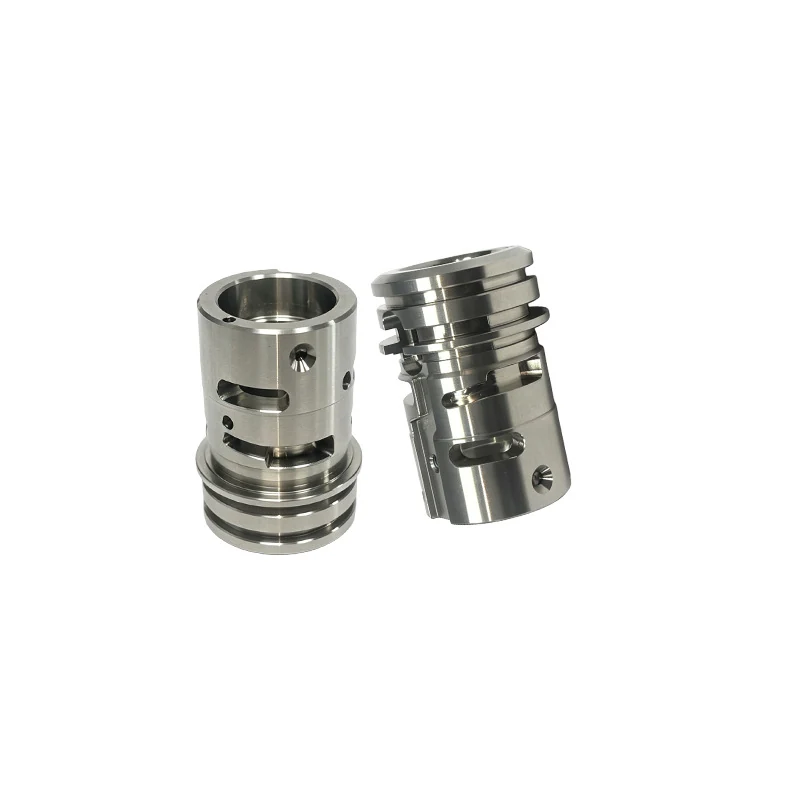 Pair of turned and milled stainless steel valve cages with slotted windows, grooves and countersunk holes
