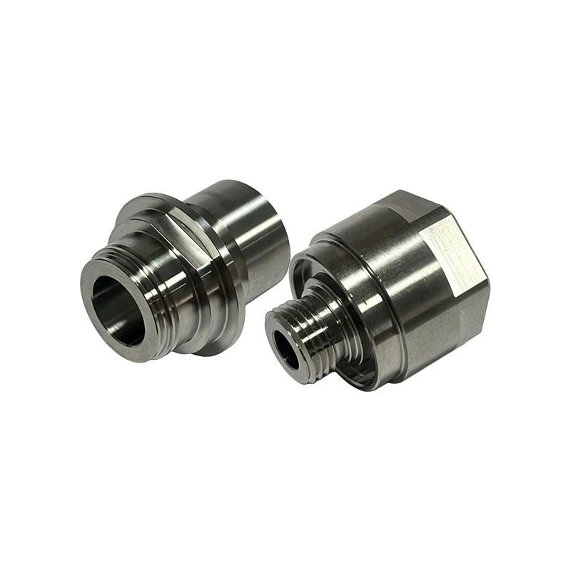 Pair of turned stainless steel threaded adapters, one with a hex flat