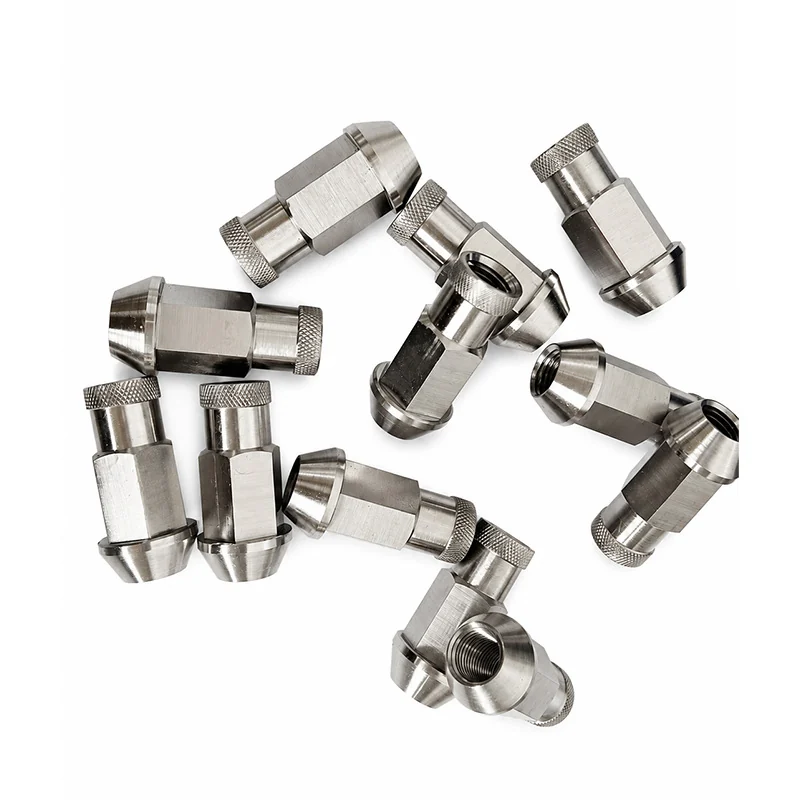 Batch of turned titanium fittings with knurled collars and threaded bores