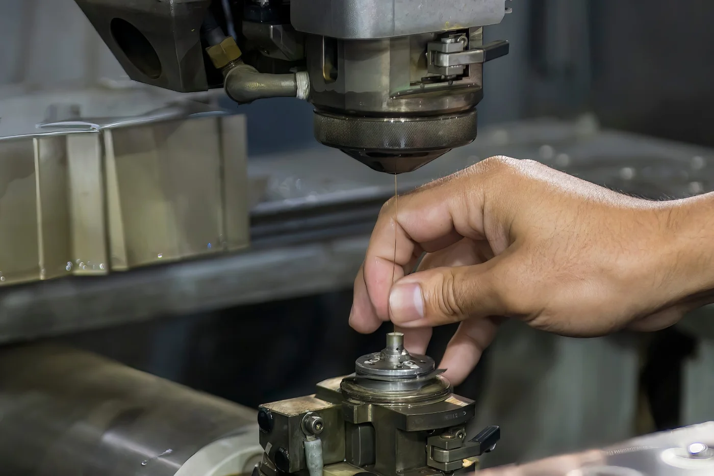 Operator threading the wire on a wire EDM machine before cutting a machined part
